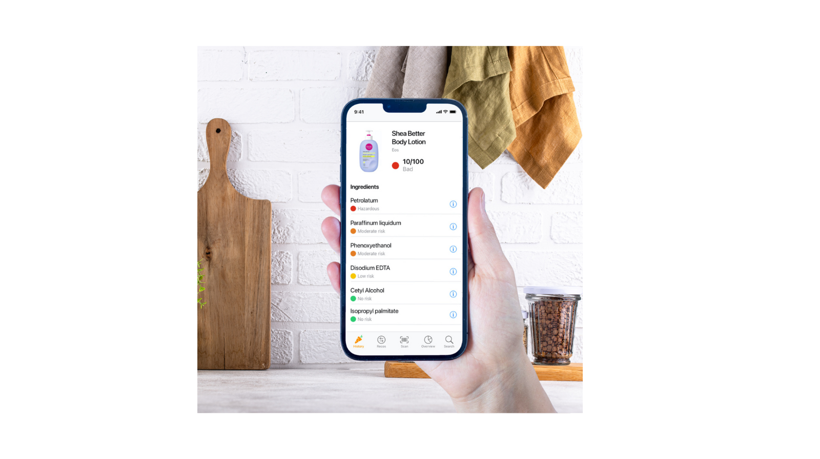 Hand holding a smartphone scanning a body lotion with the Yuka app, showing a low health score for cosmetic ingredients.